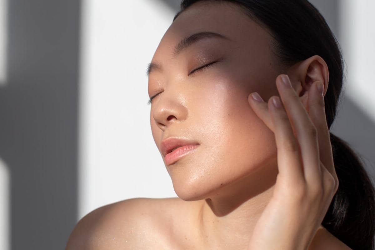 Ilustrasi perempuan berkulit wajah sehat dan bercahaya dengan riasan natural, menonjolkan tampilan glowing skin.