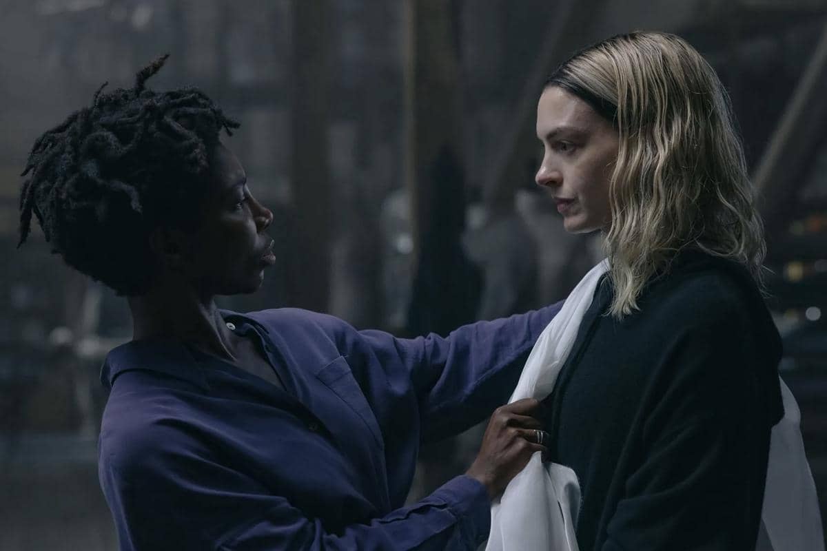 Dua karakter dalam film Mother Mary saling berhadapan dengan ekspresi tegang di ruangan gelap bernuansa dramatis.