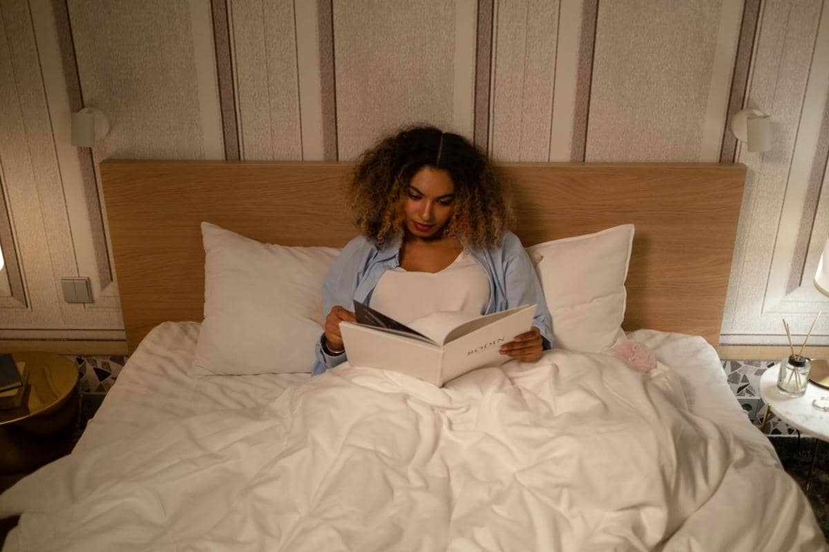 Ilustrasi Seorang Perempuan Sedang Membaca Buku Sebelum Tidur