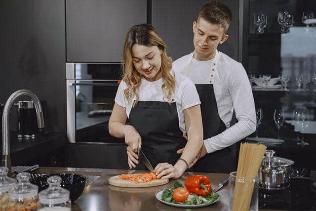 seorang pria yang menemai pasangannya memasak