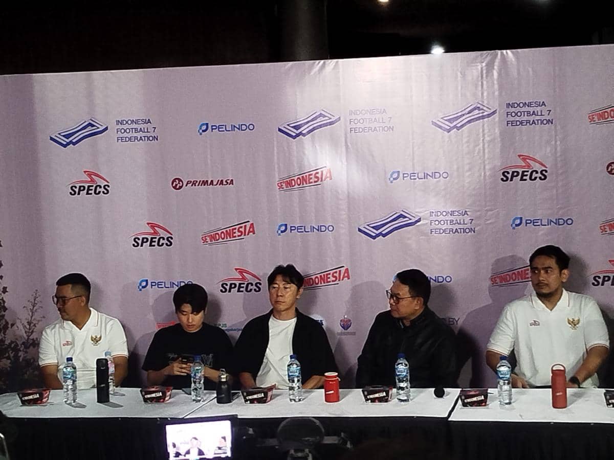 Beberapa anggota Timnas 7 Football Indonesia duduk di meja konferensi pers dengan latar belakang logo federasi dan sponsor.