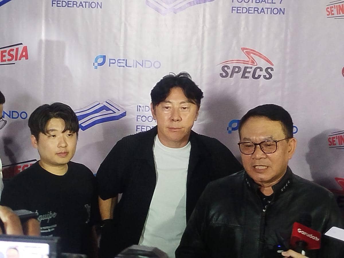 Tiga pria berdiri di depan latar bertuliskan Indonesia Football 7 Federation saat konferensi pers persiapan Timnas 7 Football Indonesia ke Italia.
