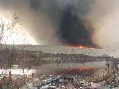 Asap hitam tebal membumbung dari area kebakaran di TPA Jatiwaringin dengan api yang masih menyala di tengah tumpukan sampah.