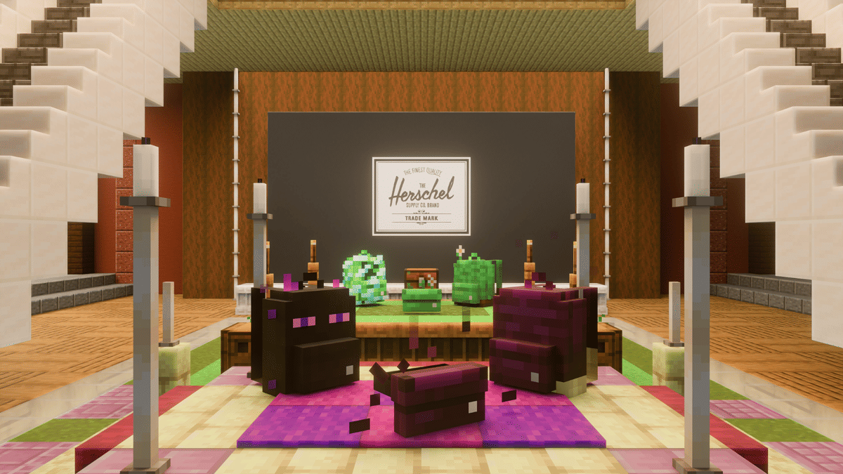 Tampilan acara Herschel Block Party dengan dekorasi bergaya voxel menampilkan tas berwarna hijau, ungu, dan hitam di atas panggung.