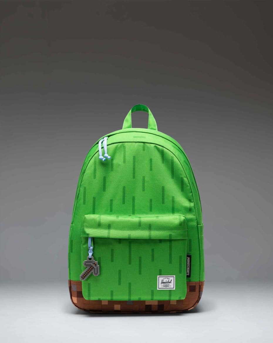Tas ransel hijau edisi khusus Herschel Block Party dengan motif piksel dan gantungan kunci berbentuk alat tambang di resleting depan.