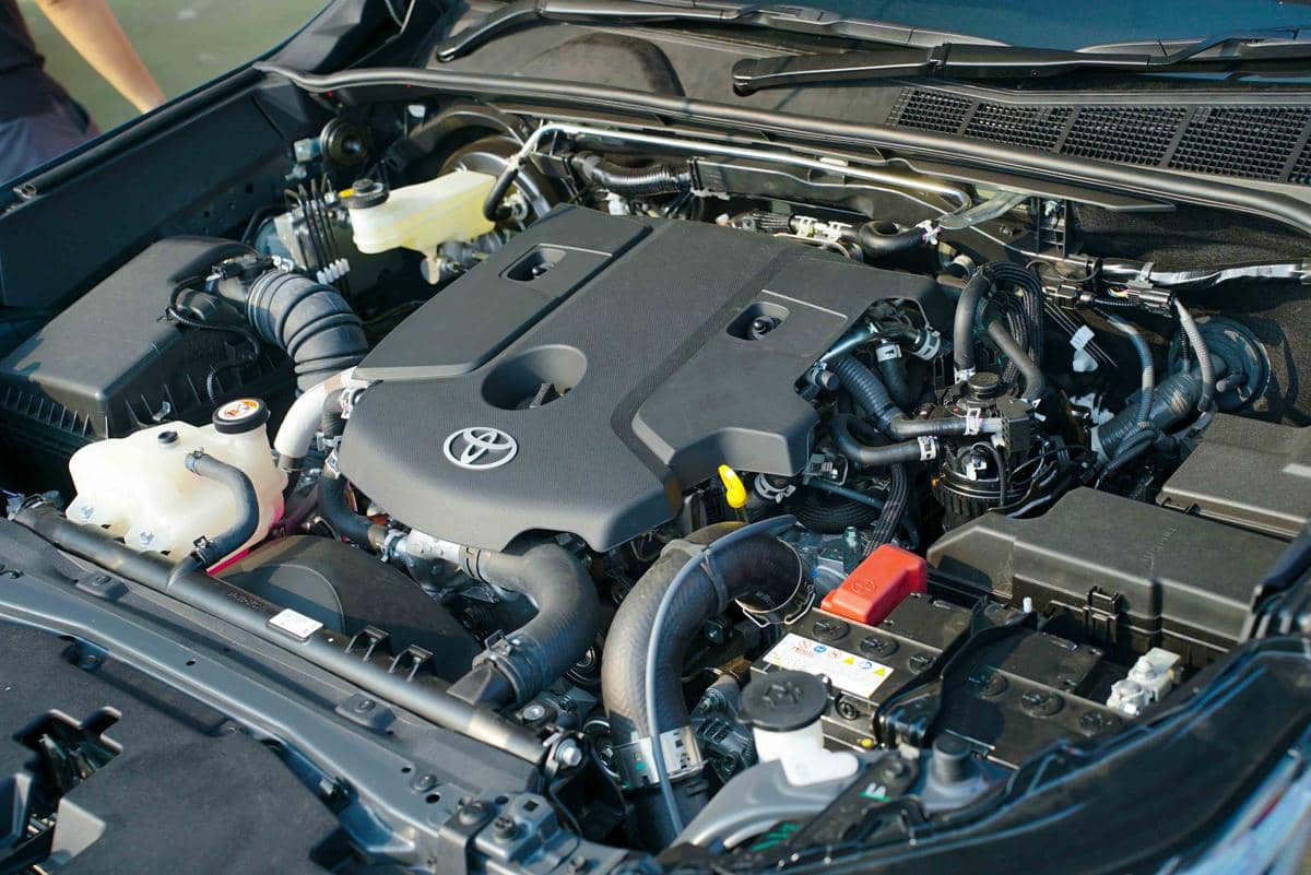 Mesin diesel 2.8 liter pada New Hilux dengan komponen mesin modern dan logo Toyota di bagian penutup mesin.