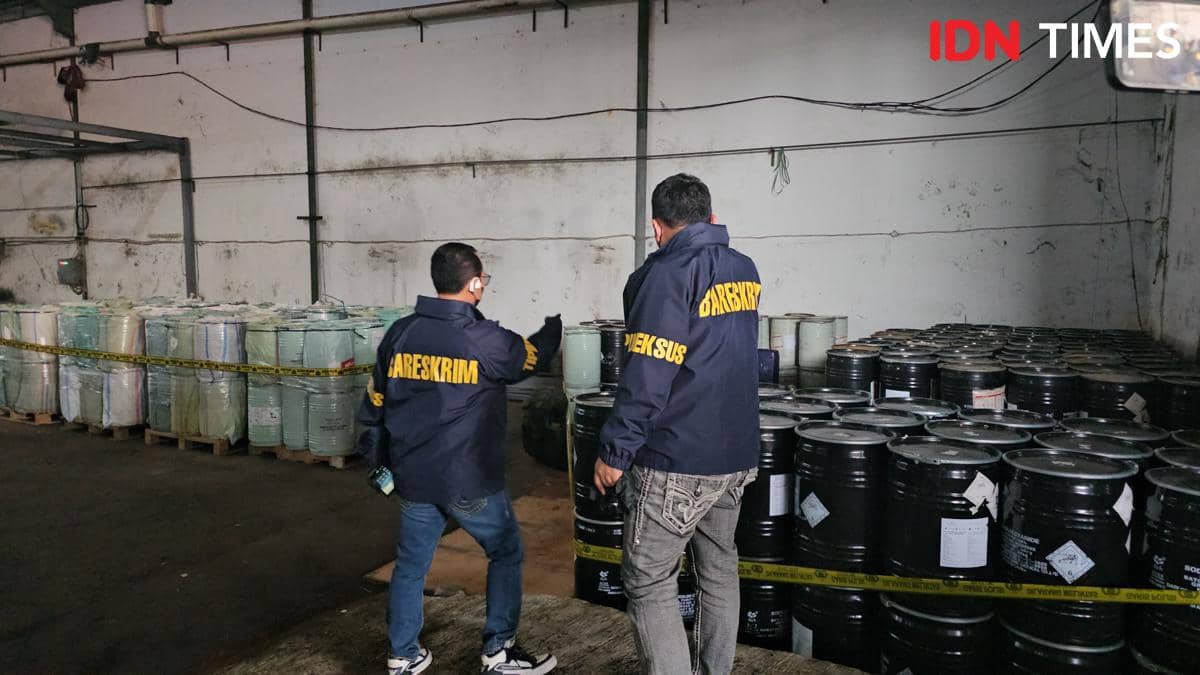 Petugas Bareskrim Polri memeriksa deretan drum berisi bahan kimia yang disita di dalam gudang di Jakarta.