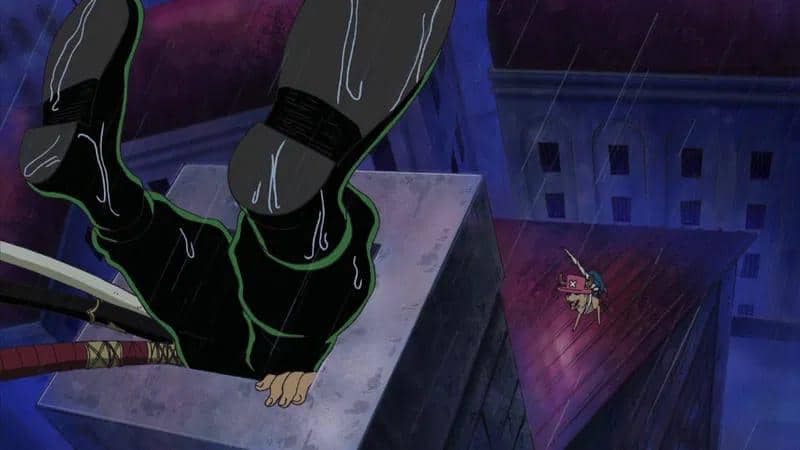 Zoro terjebak di cerobong asap saat hujan malam, dengan Chopper terlihat di atap bangunan lain dalam suasana gelap.