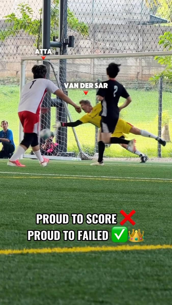 Seorang pemain sepak bola menendang bola ke arah gawang saat kiper berusaha menepisnya di lapangan futsal dalam ruangan.