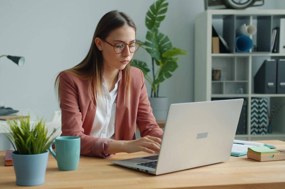 seorang wanita yang fokus bekerja dengan laptop