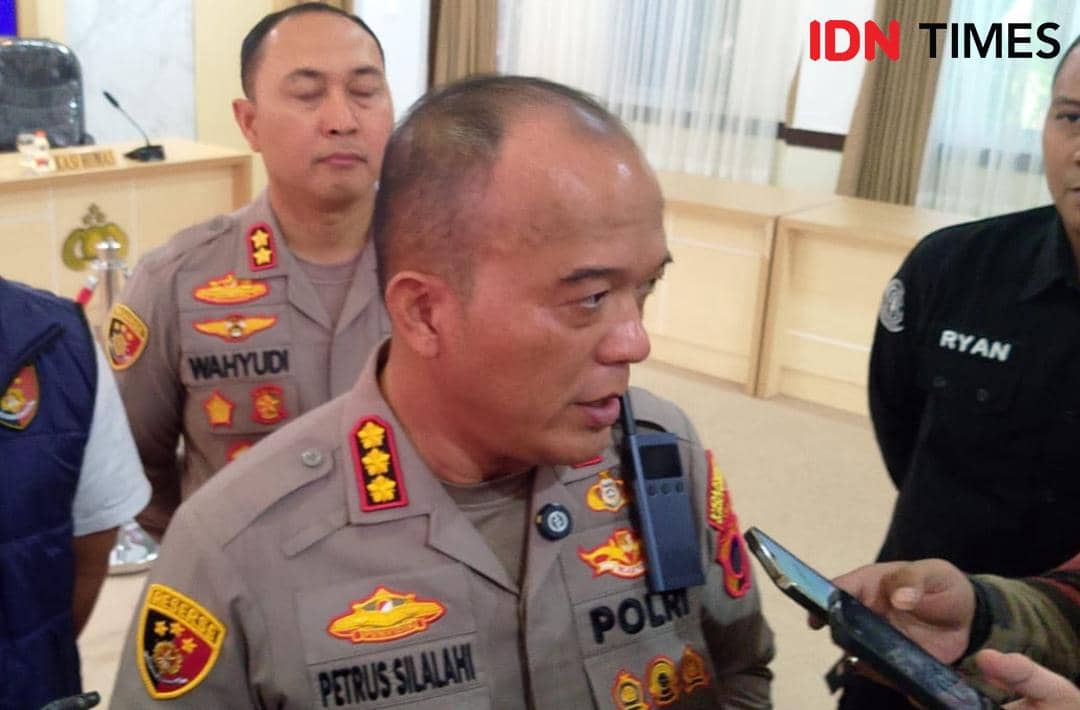 Seorang perwira polisi berpakaian dinas berbicara kepada wartawan di dalam ruangan, didampingi beberapa anggota polisi lainnya.