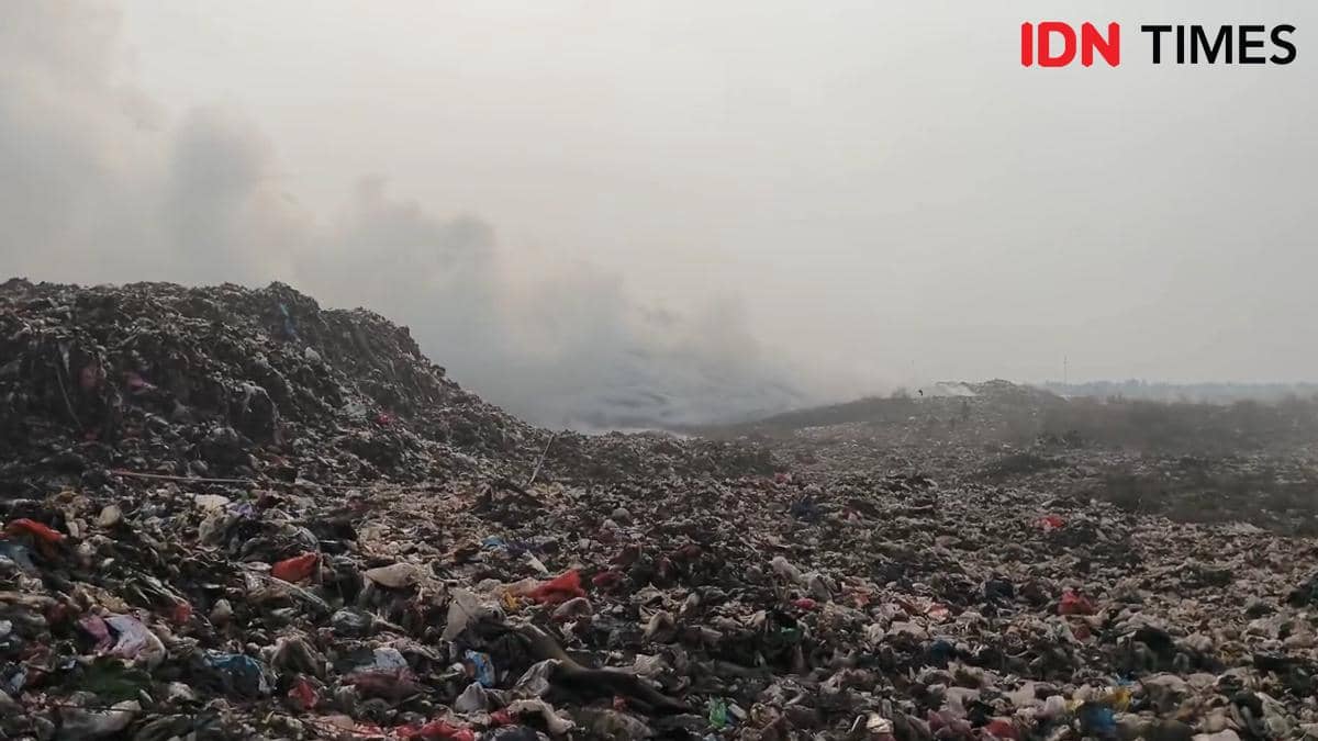 Asap tebal membubung dari tumpukan sampah besar di TPA Jatiwaringin akibat kebakaran yang melanda area pembuangan akhir.