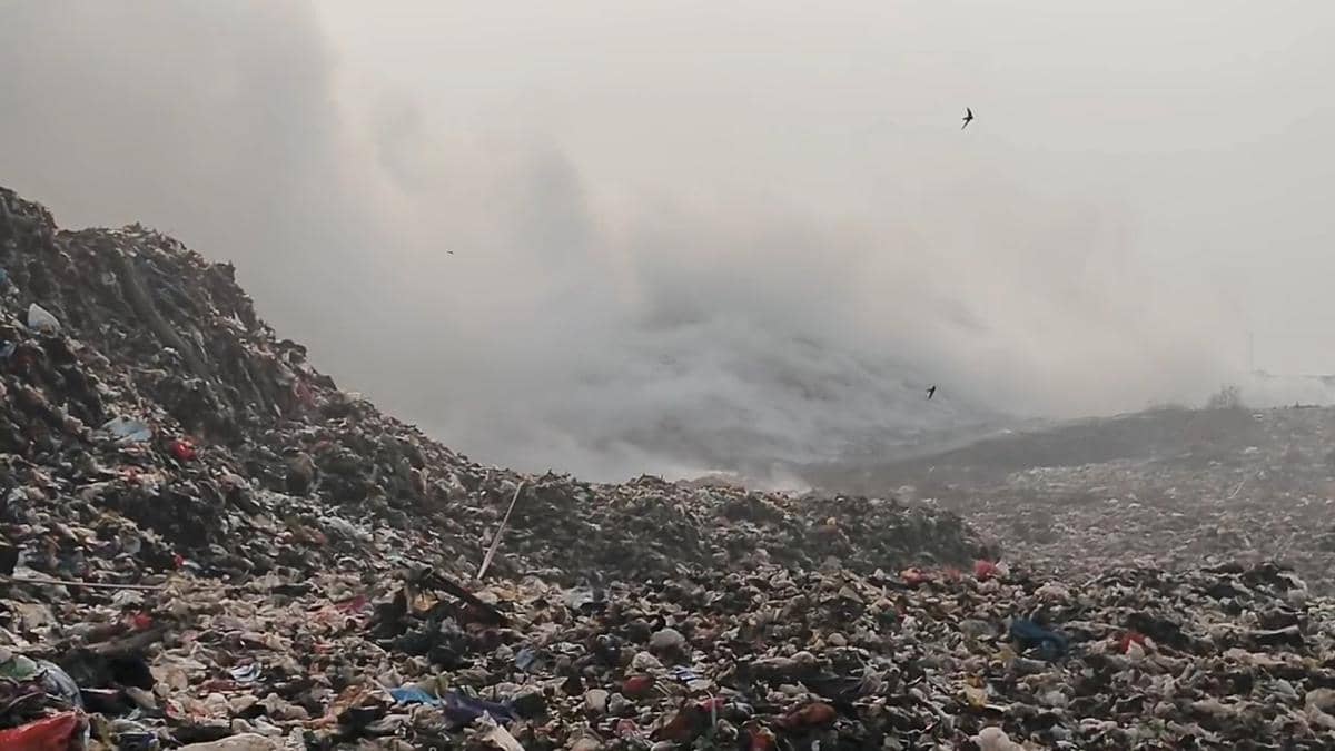 Asap tebal mengepul dari tumpukan sampah besar di TPA Jatiwaringin akibat kebakaran yang melanda area pembuangan akhir.