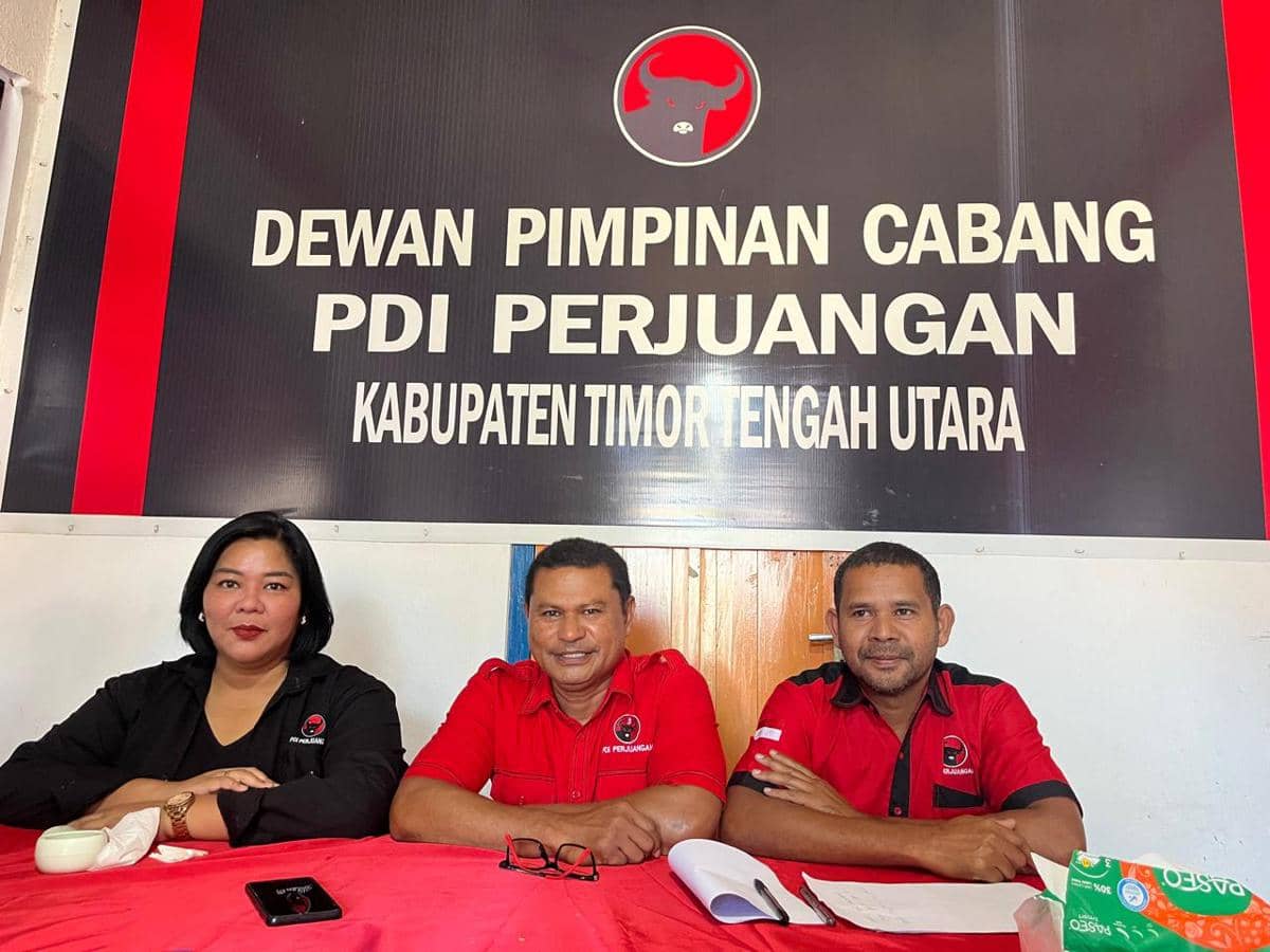 Tiga pengurus DPC PDI Perjuangan Kabupaten Timor Tengah Utara duduk di meja dengan latar belakang papan nama organisasi partai.