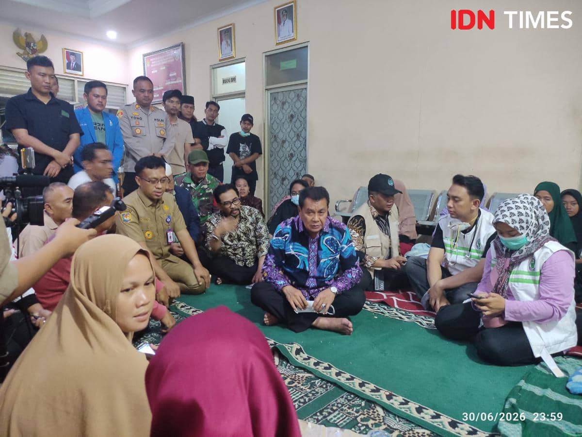 Seorang pejabat daerah bersama aparat dan relawan duduk bersama warga di tempat pengungsian korban asap kebakaran TPA Jatiwaringin.