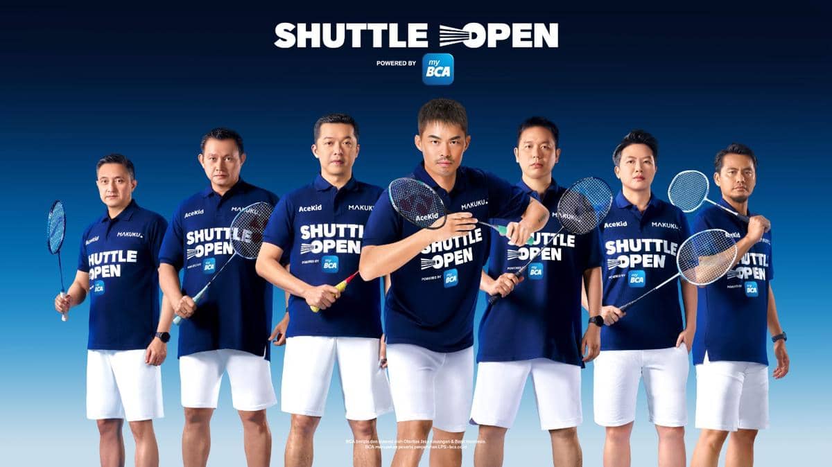 Tujuh pemain bulu tangkis mengenakan seragam biru bertuliskan Shuttle Open sambil memegang raket di depan latar biru.