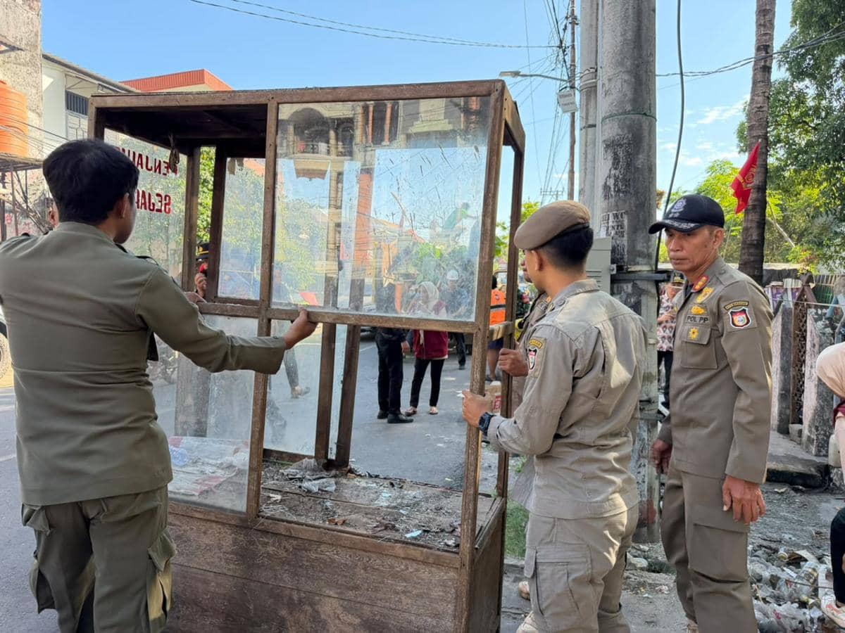 Petugas Satpol PP Makassar membongkar lapak pedagang di kawasan pasar tumpah Jalan AMD, Kecamatan Manggala, Makassar.