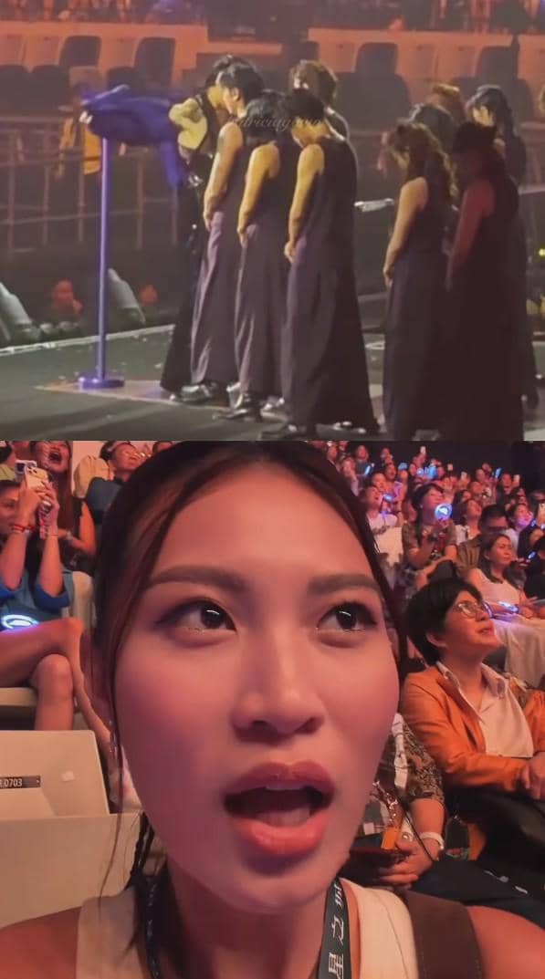 Seorang wanita berekspresi kagum di konser dalam ruangan yang dipenuhi penonton, sementara di panggung beberapa penari tampil bersama.