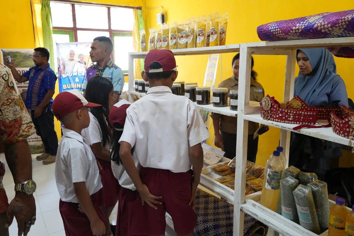 Sejumlah siswa berseragam merah putih melihat produk lokal seperti makanan kemasan dan kerajinan di stan pameran sekolah.