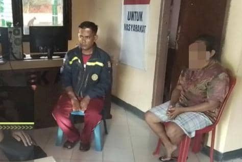 Seorang pria dan seorang perempuan duduk di dalam ruangan kantor polisi di Kupang, dengan latar belakang spanduk bertuliskan pesan pelayanan masyarakat.