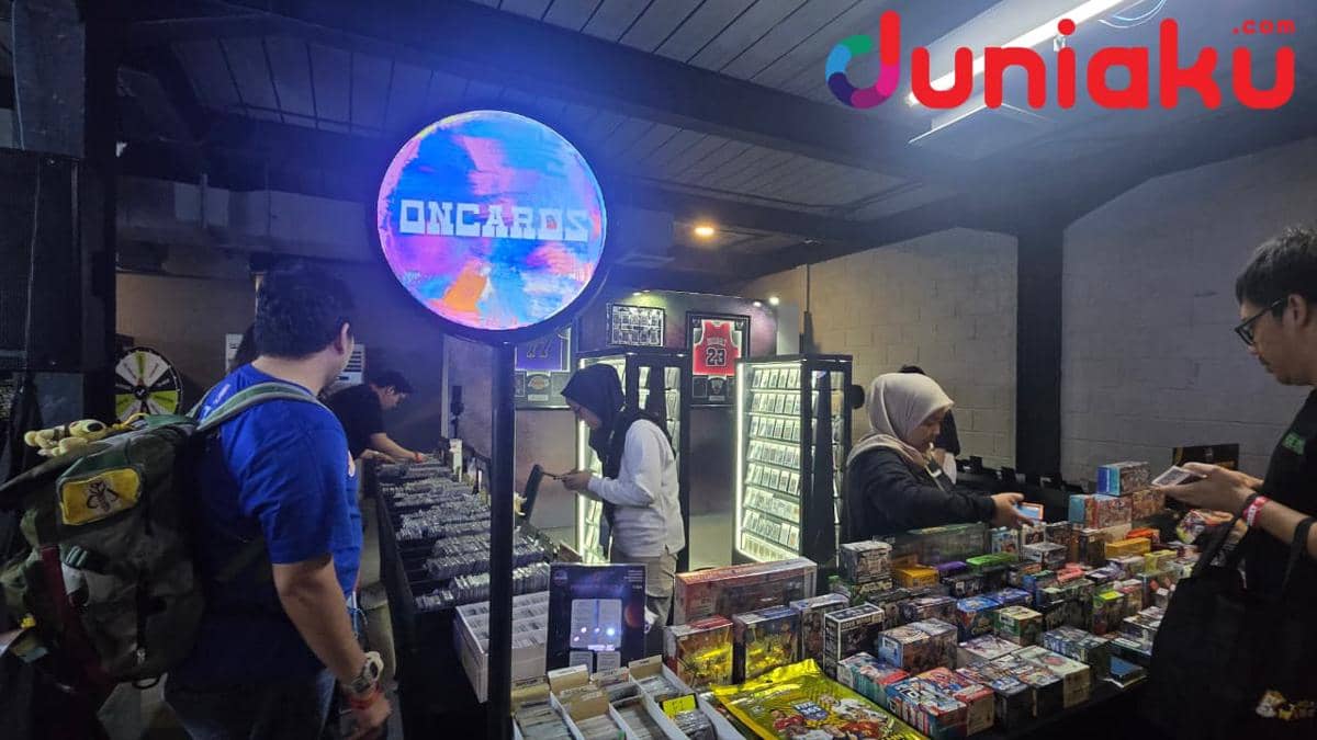 Pengunjung melihat dan membeli kartu koleksi di stan Oncards dalam acara The Market Vol. 3 by FanCon di ruangan tertutup.