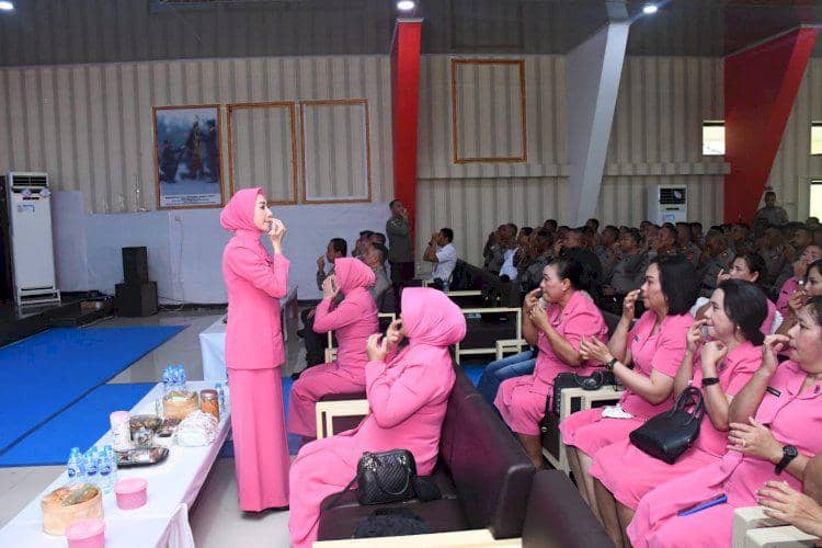 Seorang perempuan berseragam pink memimpin sesi terapi di depan anggota Bhayangkari yang duduk mengenakan seragam serupa di sebuah aula.