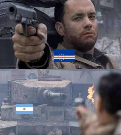 Adegan film dengan pria memegang pistol berlabel bendera Cape Verde menghadap tank besar berlabel bendera Argentina.