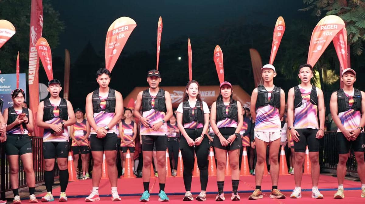 Para pelari mengenakan seragam berwarna cerah berdiri di garis start acara Bhinneka Run 2026 di Jakarta pada malam hari.