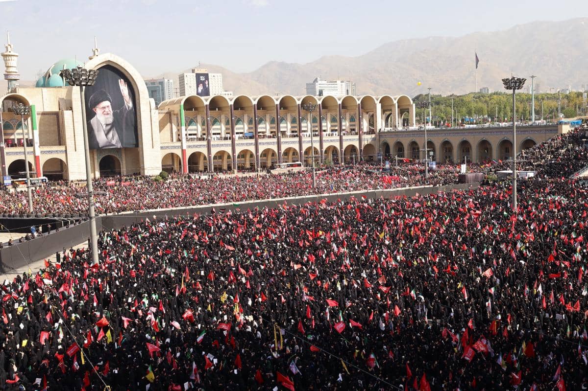 Ribuan pelayat berpakaian hitam dan membawa bendera merah memadati area luas di depan bangunan besar berkubah di Iran.