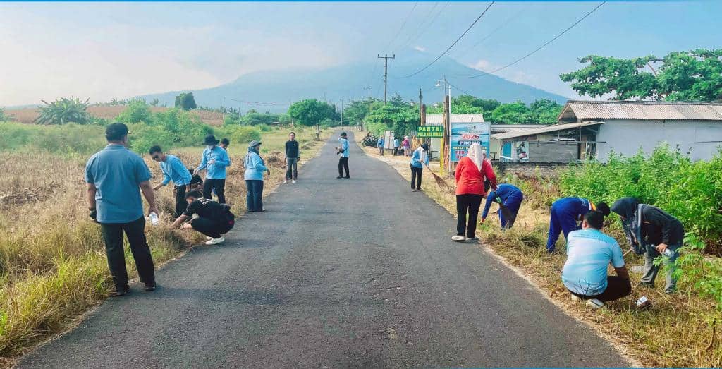 Sejumlah Aparatur Sipil Negara membersihkan area pinggir jalan di Kota Kalianda, Lampung Selatan dengan latar pegunungan dan cuaca cerah.