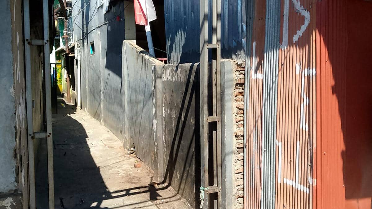 Lorong sempit di Jalan Mannuruki II, Kelurahan Mangasa, Makassar, dengan dinding seng dan tembok yang tampak bersih setelah dibersihkan.