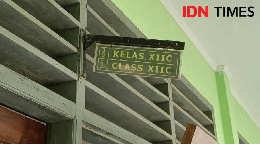 Plang bertuliskan Kelas XII C di depan ruang kelas SLB Negeri Kota Radja dengan dinding berwarna hijau muda.