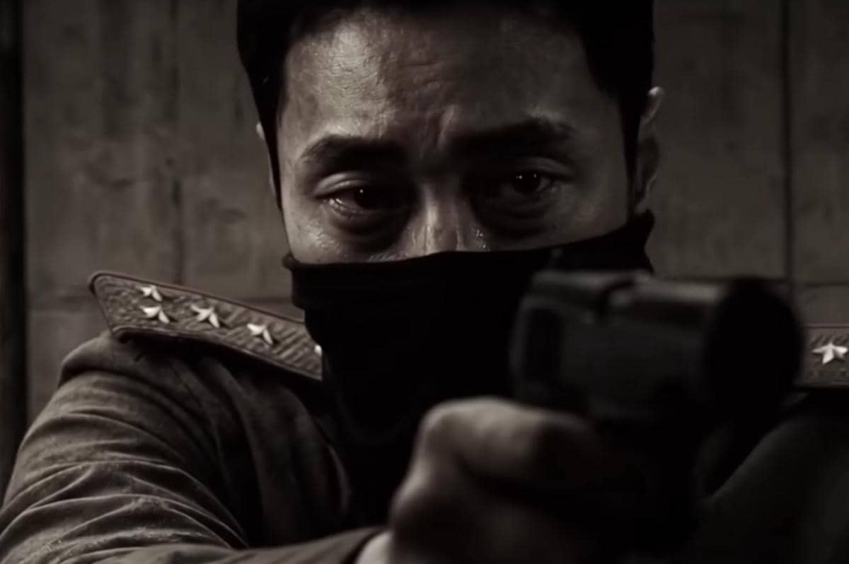 Seorang pria berpakaian militer dengan masker hitam menodongkan pistol dalam adegan tegang dari drama Agent Kim Reactivated.