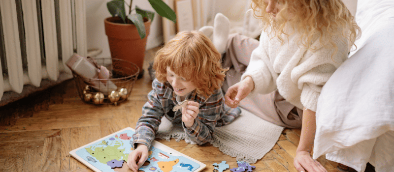 Ibu dan putranya bermain puzzle bersama.
