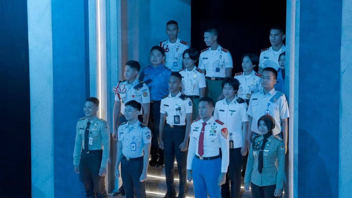 Sekelompok peserta muda berseragam berdiri di bawah pencahayaan biru dalam acara Clash of Champions.