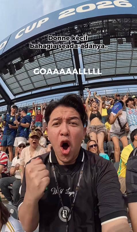 Seorang penonton mengenakan jersey hitam bersorak gembira di stadion saat pertandingan Piala Dunia 2026 antara Norwegia dan Brasil.