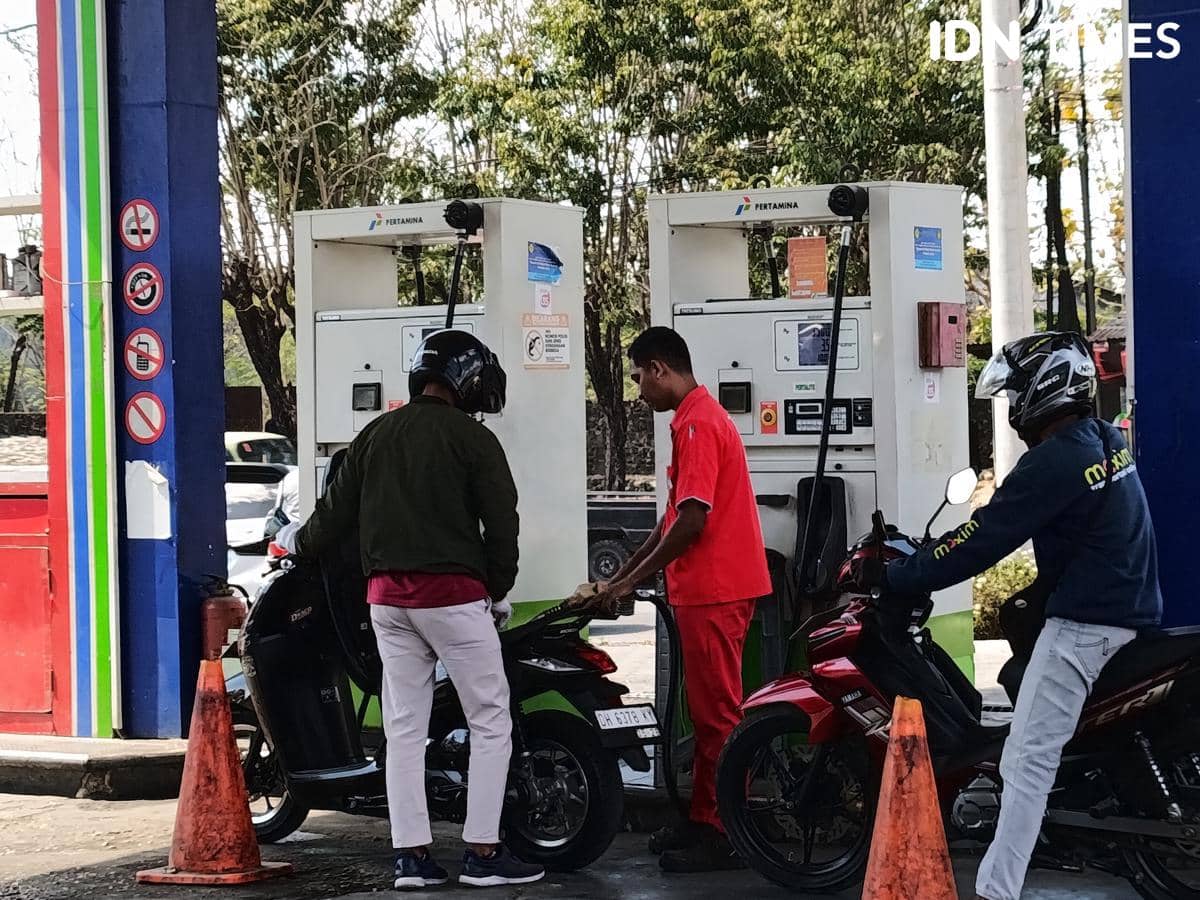 Petugas SPBU mengisi BBM Pertalite ke motor pelanggan di salah satu stasiun pengisian bahan bakar di Kota Kupang.