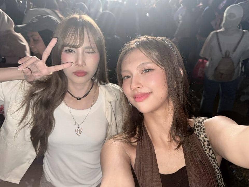 Dua perempuan berpose selfie di tengah keramaian malam hari saat menghadiri Prambanan Jazz Festival 2026.