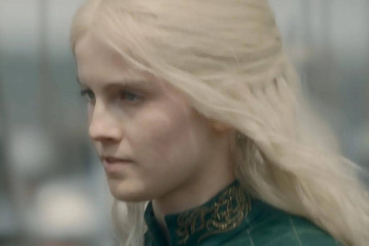 Karakter berambut pirang panjang mengenakan pakaian hijau berhias emas dalam cuplikan serial House of the Dragon Season 3.