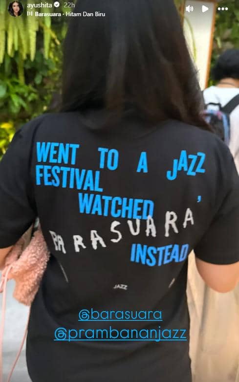 Seorang perempuan mengenakan kaus hitam bertuliskan 'Went to a Jazz Festival Watched Barasuara Instead' saat menghadiri Prambanan Jazz Festival 2026.