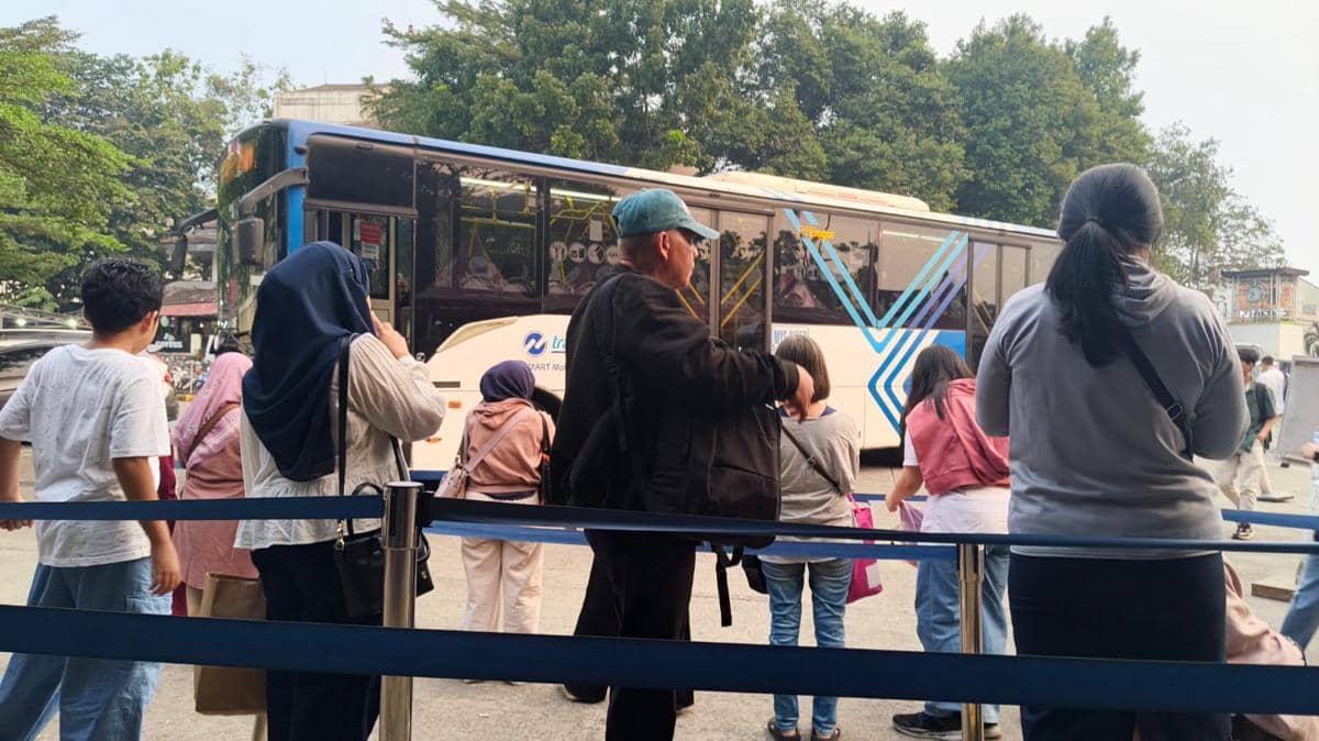 Sejumlah warga Bogor mengantre untuk naik bus Transjabodetabek P11 di terminal Botani Square Bogor pada siang hari.
