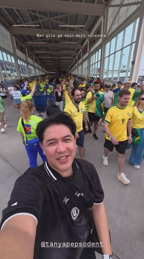 Seorang pria berfoto selfie di antara kerumunan suporter Brasil yang mengenakan jersey kuning di area stadion Piala Dunia 2026.