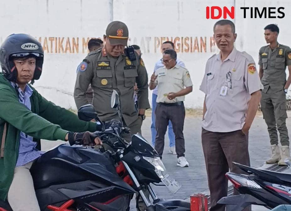 Petugas Bapenda NTT bersama Satpol PP memantau pengendara motor di SPBU terkait aturan penggunaan BBM untuk kendaraan taat pajak.
