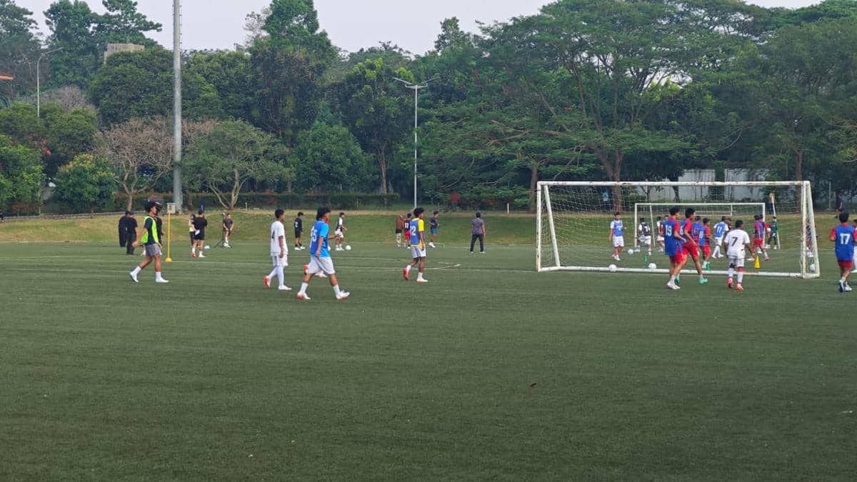 Para peserta bermain sepak bola di lapangan rumput dalam kegiatan Summer Camp 2026 yang diselenggarakan oleh ASICS.