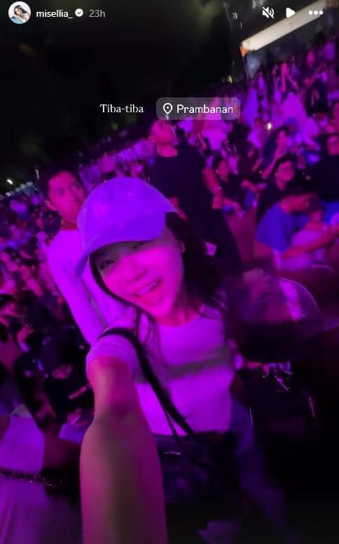 Seorang perempuan berpose selfie di tengah keramaian penonton konser malam hari dengan pencahayaan ungu di Prambanan Jazz Festival 2026.