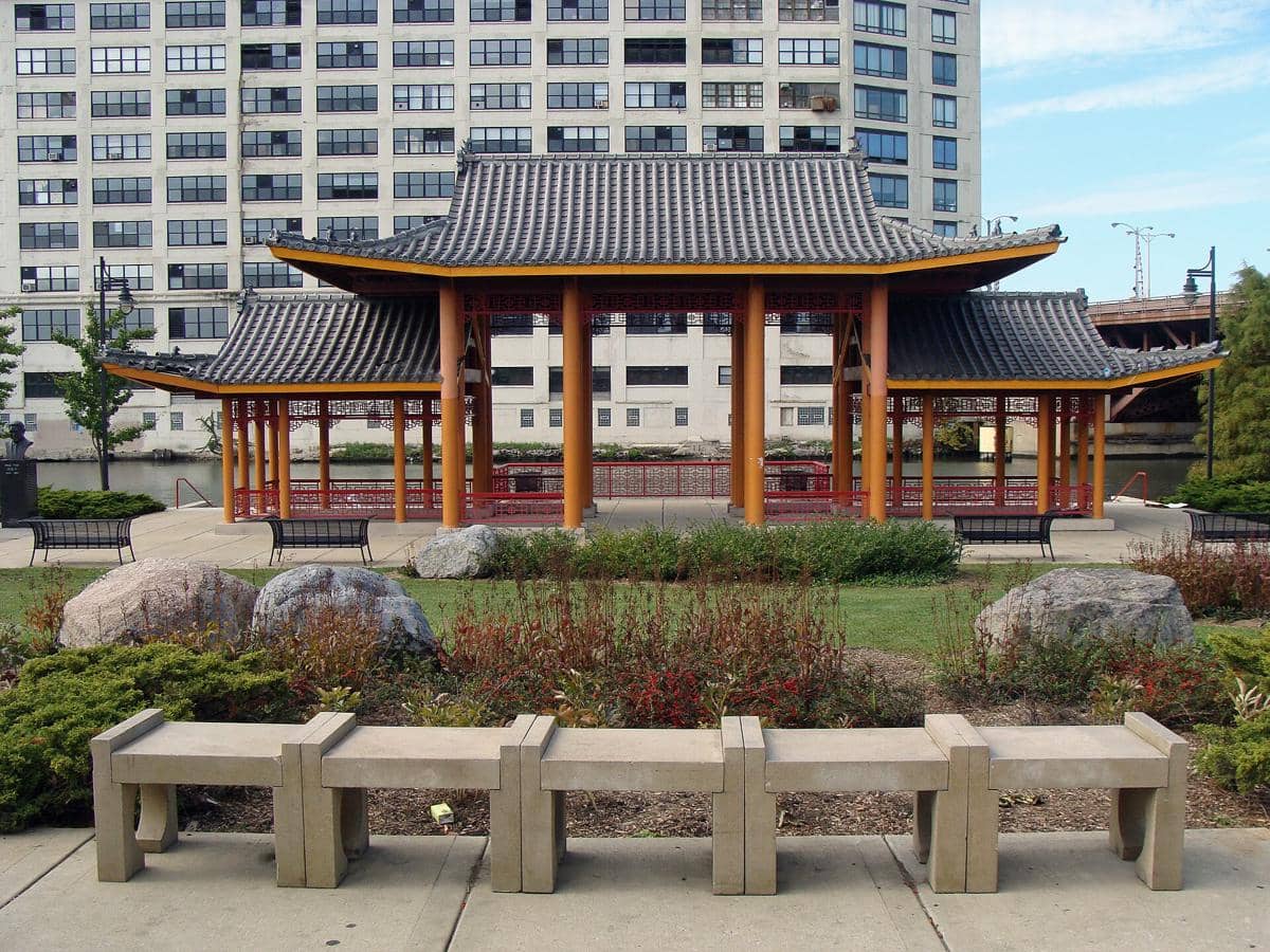 Paviliun bergaya arsitektur Asia di Ping Tom Memorial Park dengan latar gedung tinggi dan taman hijau di sekitarnya.