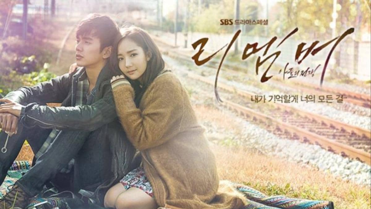 Dua orang duduk di tepi rel kereta api dengan latar musim gugur dalam poster drama Korea Remember: War of Son.