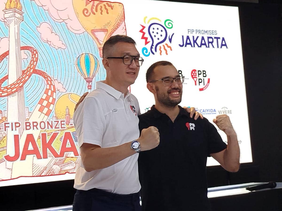 Dua pria berpose dengan tangan mengepal di depan layar bertuliskan FIP Bronze dan FIP Promises Jakarta 2026 dengan latar ilustrasi Monas.