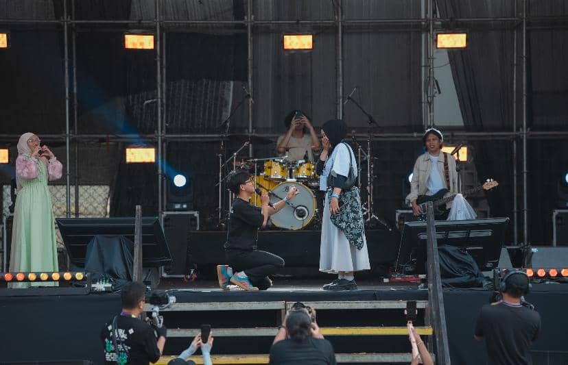 Seorang pria berlutut melamar seorang wanita di atas panggung saat pertunjukan musik berlangsung di Bigu Festival 2026.