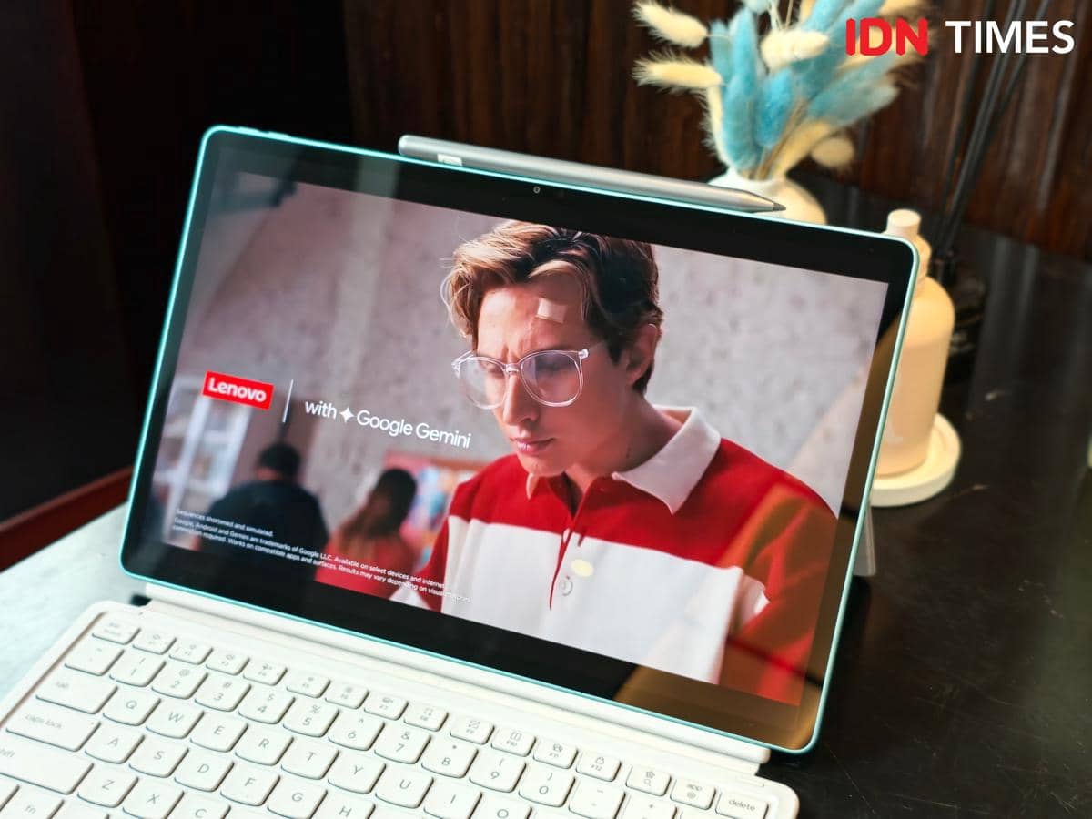 Tablet Lenovo Idea Tab Gen 2 berlayar besar menampilkan video promosi dengan logo Lenovo dan Google Gemini di atas meja kerja.
